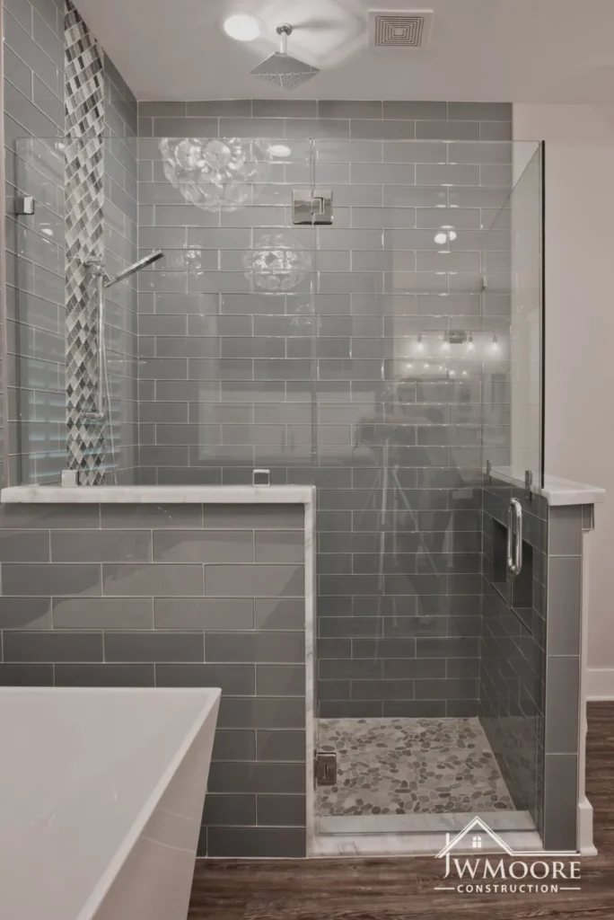 Modern glass shower with gray subway tiles.