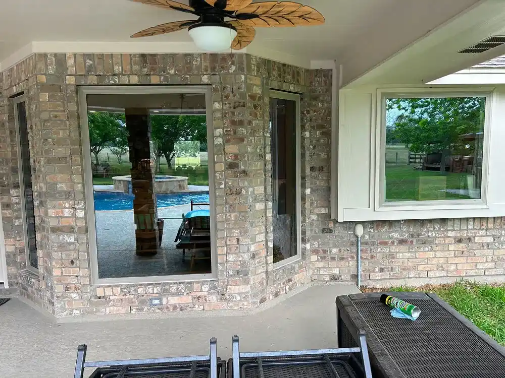 New windows installed on brick home with clear view of backyard pool.