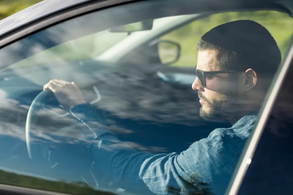 Man in sunglasses driving a car