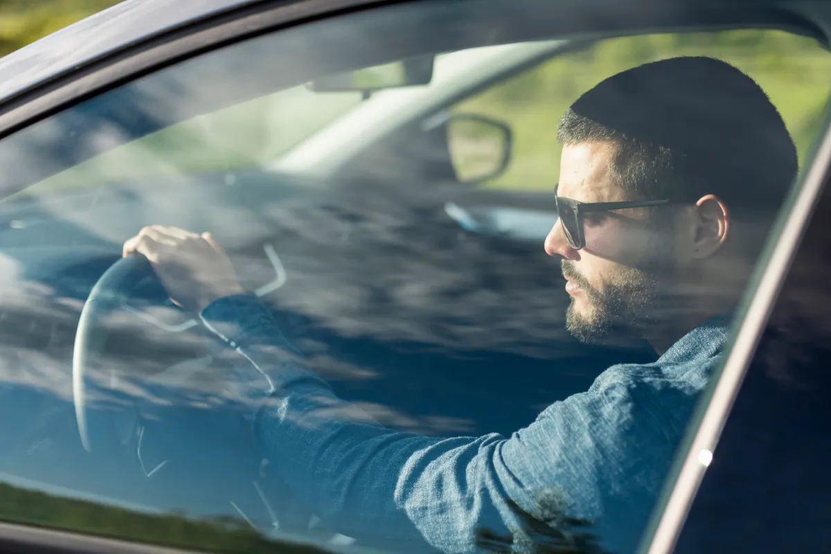 Man in sunglasses driving a car